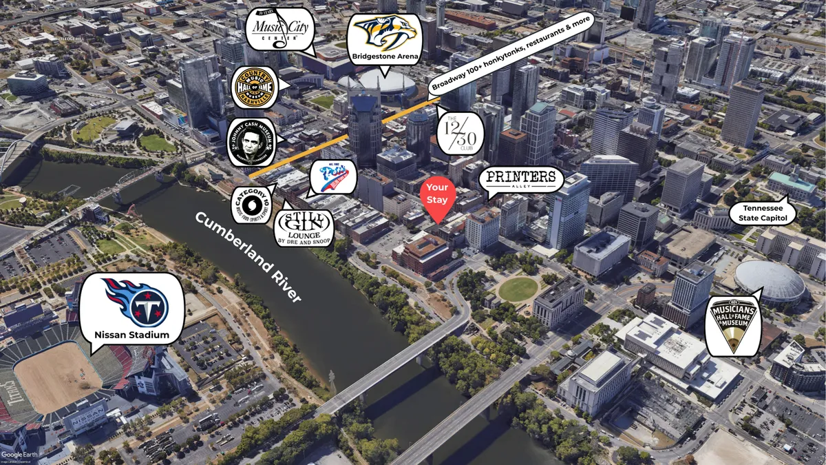 A sweeping view of downtown Nashville, featuring the Cumberland River, key city landmarks like Bridgestone Arena, Nissan Stadium, and the Tennessee State Capitol. The scene buzzes with possibilities for attending events, exploring restaurants and bars, and enjoying the city’s vibrant atmosphere.